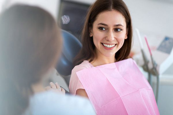 woman looking at her new smile at the dentist