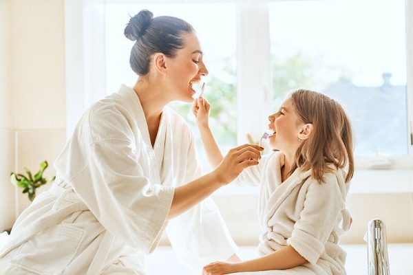 mother and daughter practicing oral hygiene care