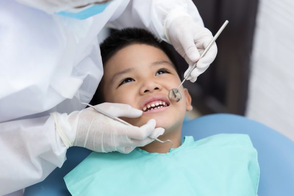 Little boy smiles up at dentist